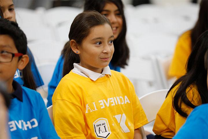 Elementary students sitting in the audience with Achieve LA shirts